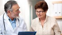 Older woman consulting with male health care provider.